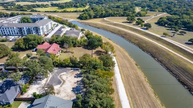 an aerial view of a house with a garden and lake view