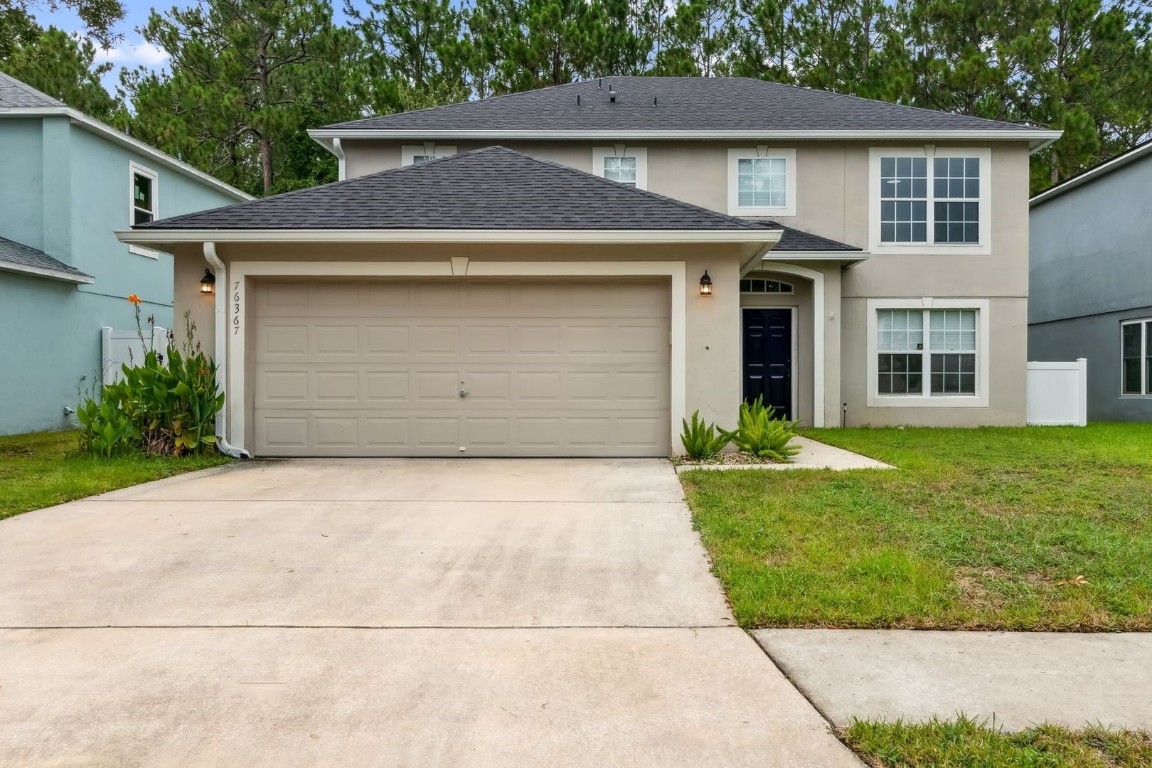 a front view of a house with a yard and garage