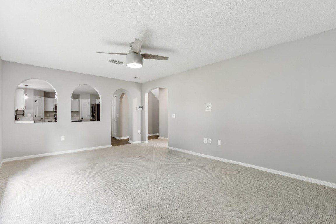 76367 Longleaf Loop Yulee, FL 32097 - Photo 11 of 49 an empty room with chandelier fan and windows