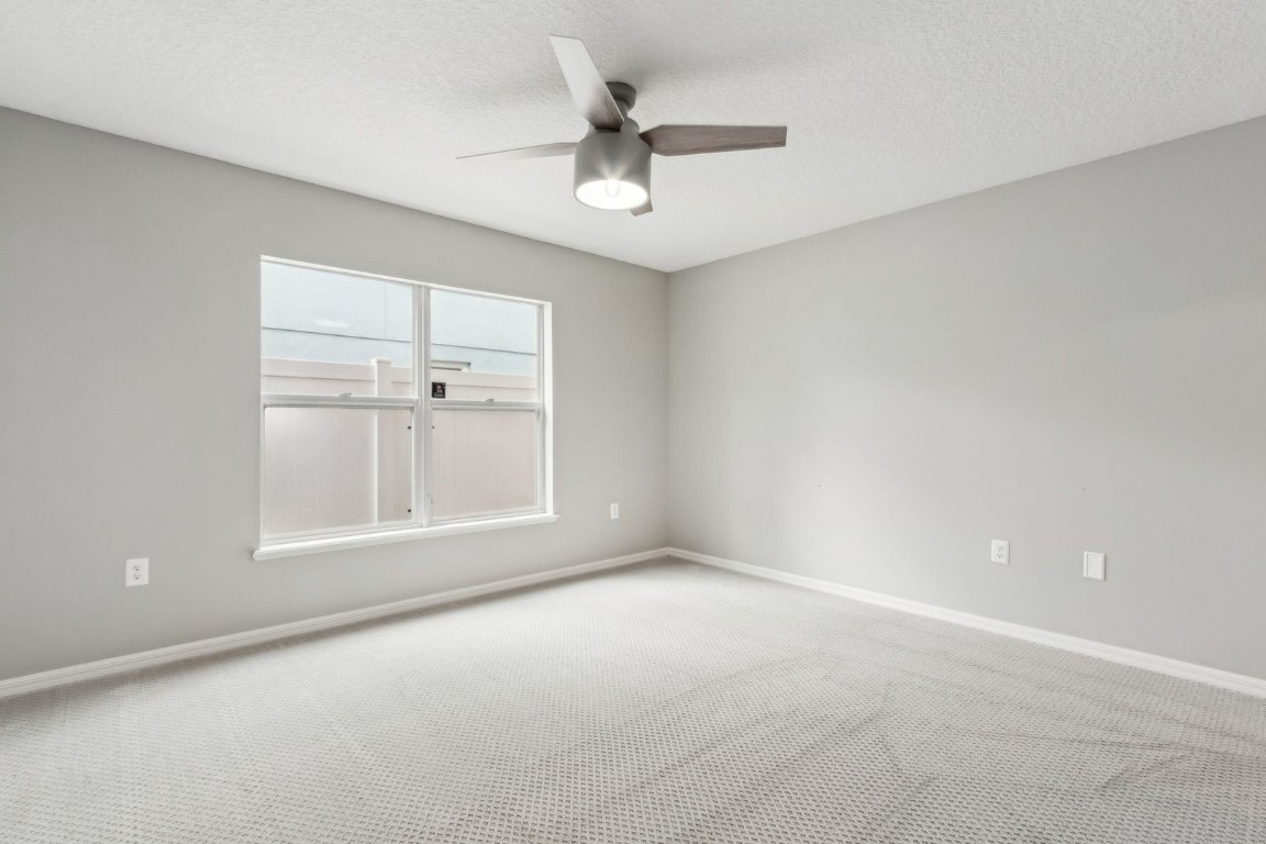 76367 Longleaf Loop Yulee, FL 32097 - Photo 15 of 49 an empty room with a ceiling fan and windows