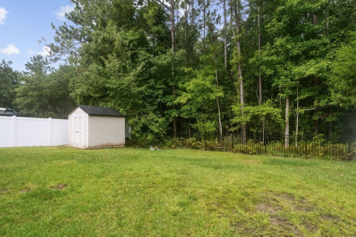 76367 Longleaf Loop Yulee, FL 32097 - Photo 37 of 49 a backyard of a house with plants and large trees