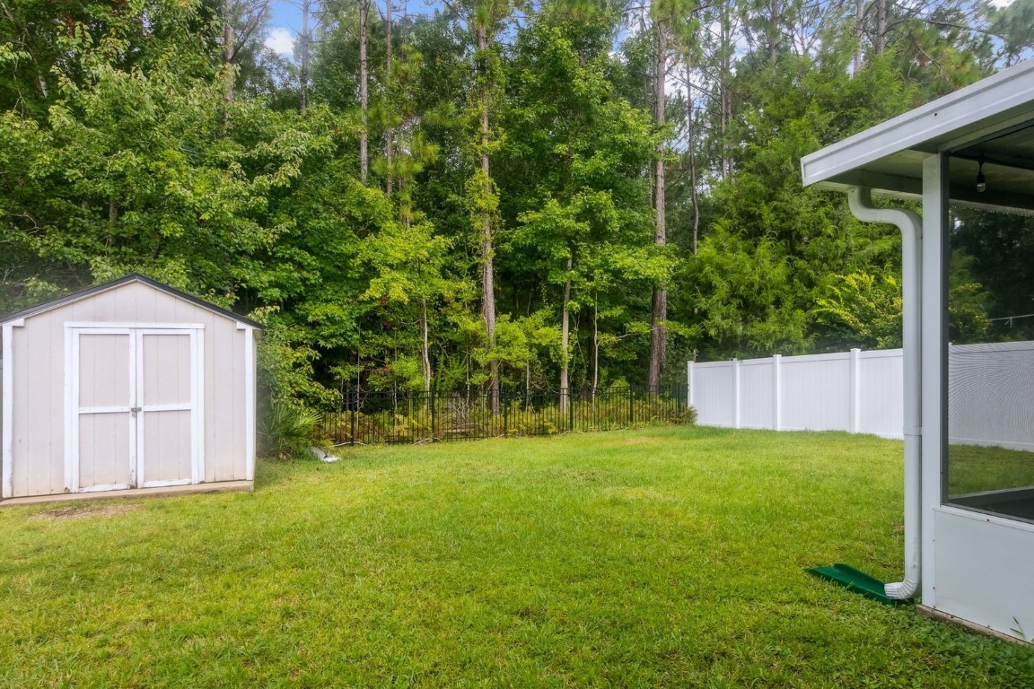 76367 Longleaf Loop Yulee, FL 32097 - Photo 38 of 49 a backyard of a house with plants and large tree