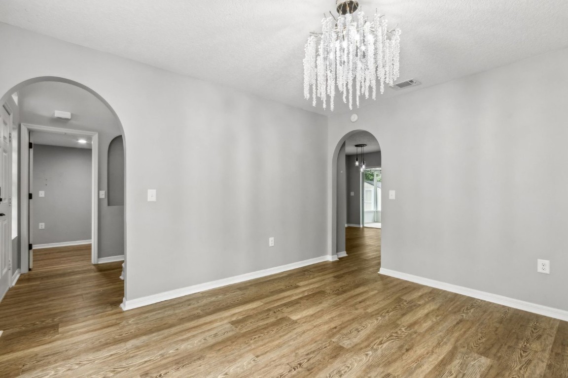 76367 Longleaf Loop Yulee, FL 32097 - Photo 4 of 49 a view of empty room with wooden floor and chandelier