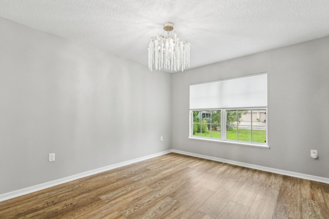 76367 Longleaf Loop Yulee, FL 32097 - Photo 5 of 49 wooden floor in an empty room with a window