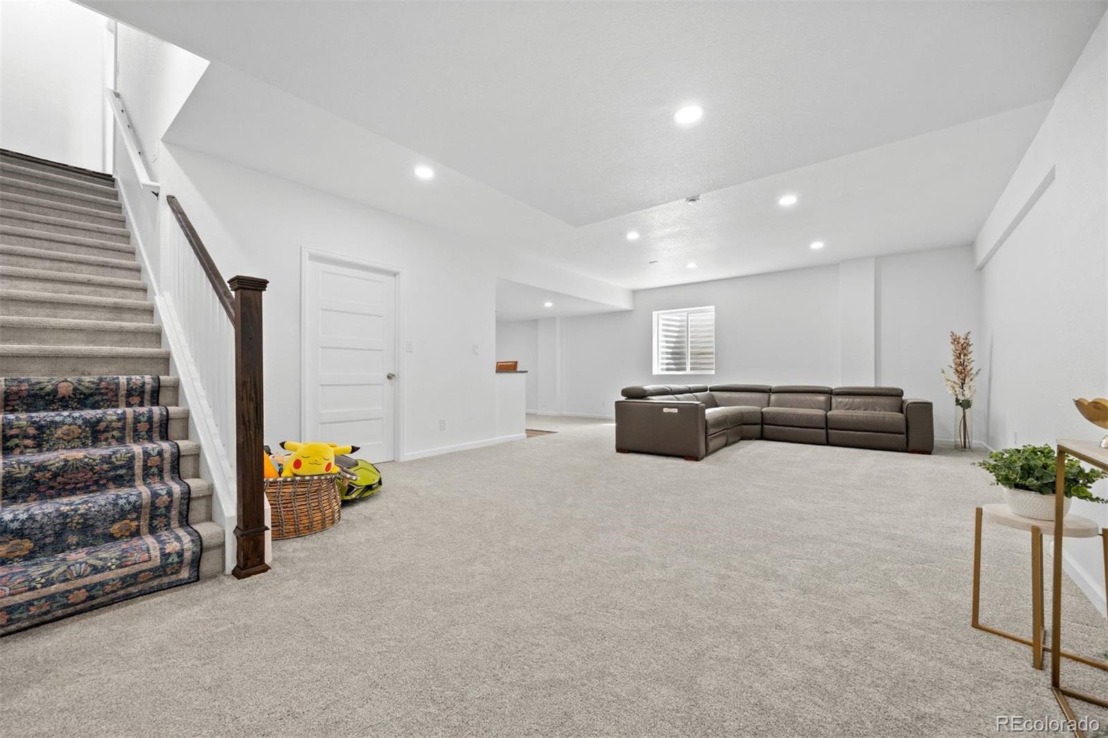 6346 Rockingham Way Castle Pines, CO 80108 - Photo 28 of 43 a large room with furniture and stairs