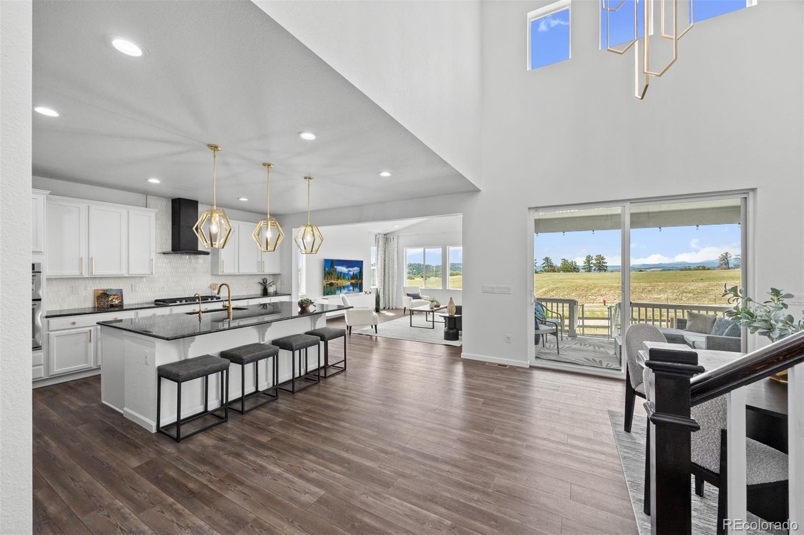 6346 Rockingham Way Castle Pines, CO 80108 - Photo 6 of 43 a large kitchen with stainless steel appliances a stove and wooden floor