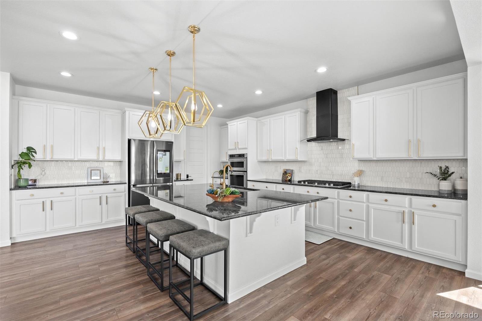 6346 Rockingham Way Castle Pines, CO 80108 - Photo 8 of 43 a kitchen with stainless steel appliances granite countertop a sink dishwasher a stove a refrigerator and white cabinets with wooden floor