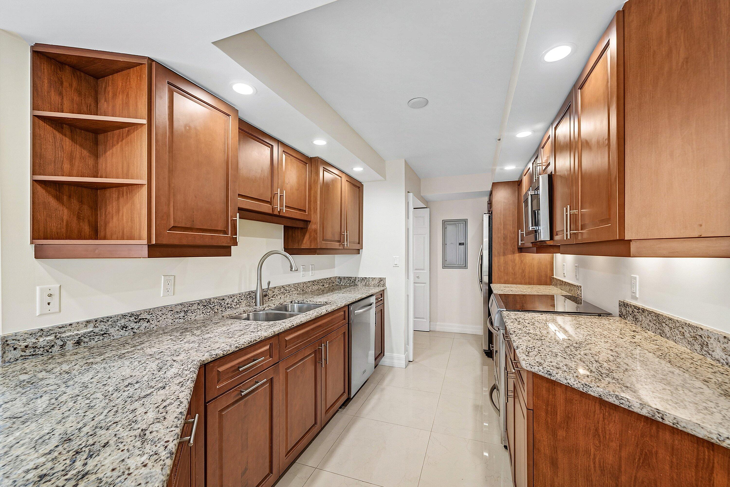 3000 North Ocean Drive, Unit 8F Singer Island, FL 33404 - Photo 3 of 66 a kitchen with granite countertop a sink stove and cabinets