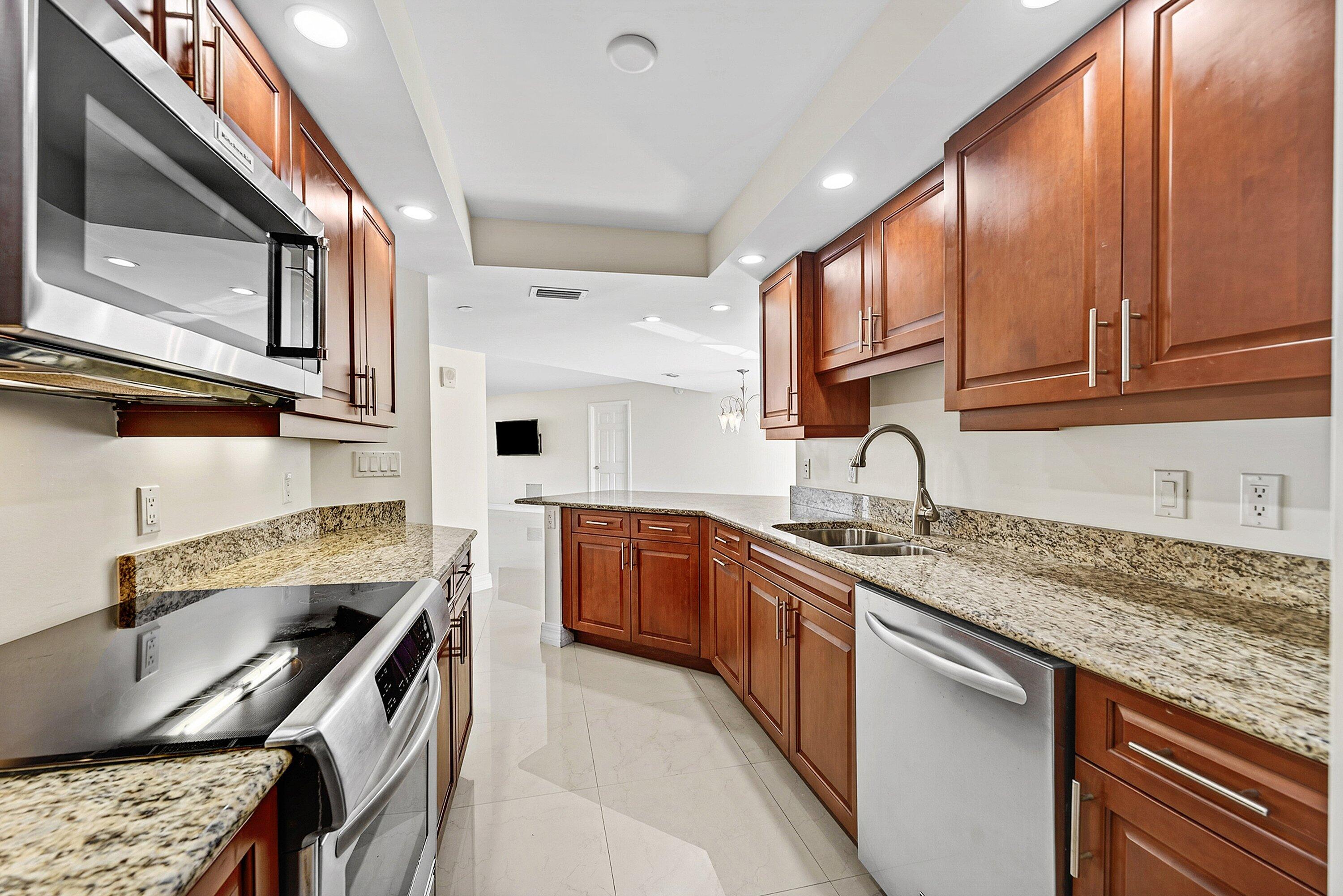 3000 North Ocean Drive, Unit 8F Singer Island, FL 33404 - Photo 4 of 66 a kitchen with stainless steel appliances granite countertop a sink stove and cabinets