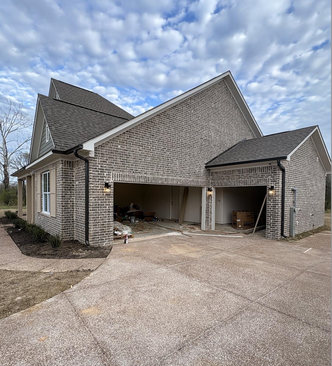 5054 Summers Road Arlington, TN 38002 - Photo 2 of 11 View of side of property featuring a garage, concrete driveway, and brick siding
