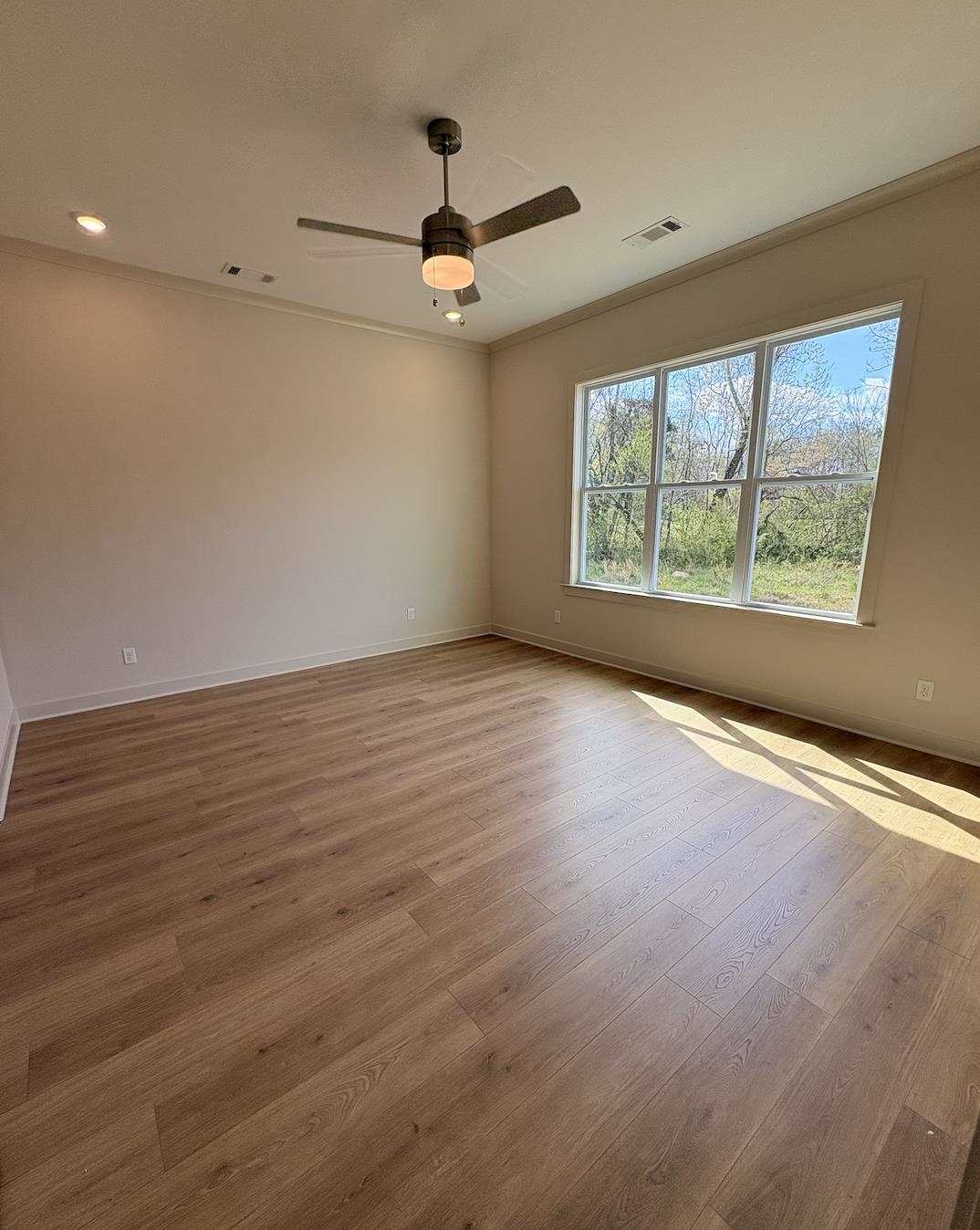5054 Summers Road Arlington, TN 38002 - Photo 3 of 11 Unfurnished room featuring light wood-style floors, a ceiling fan, and crown molding
