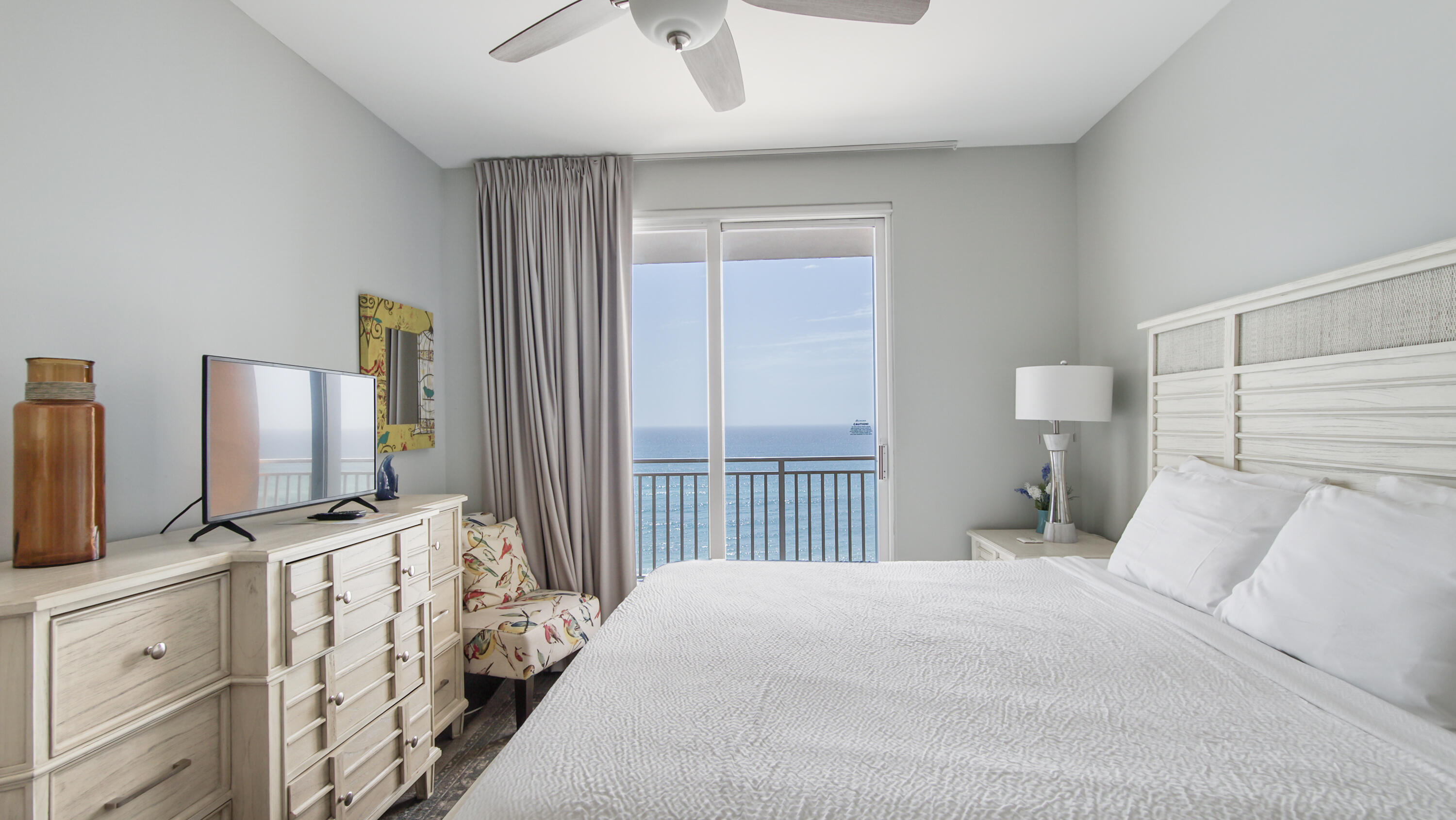 17739 Front Beach Road, Unit 507W Panama City Beach, FL 32413 - Photo 15 of 49 a bedroom with a bed flat screen tv and window