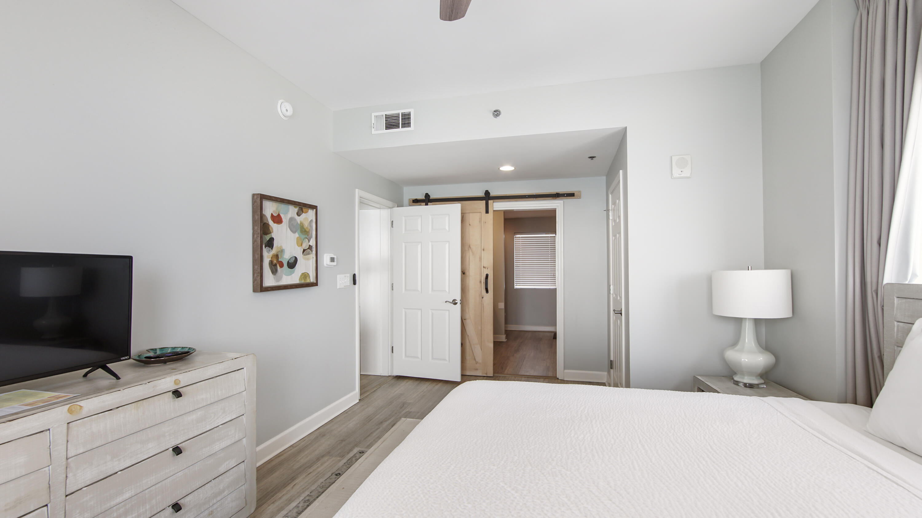 17739 Front Beach Road, Unit 507W Panama City Beach, FL 32413 - Photo 21 of 49 a bedroom with a bed and a flat screen tv in it