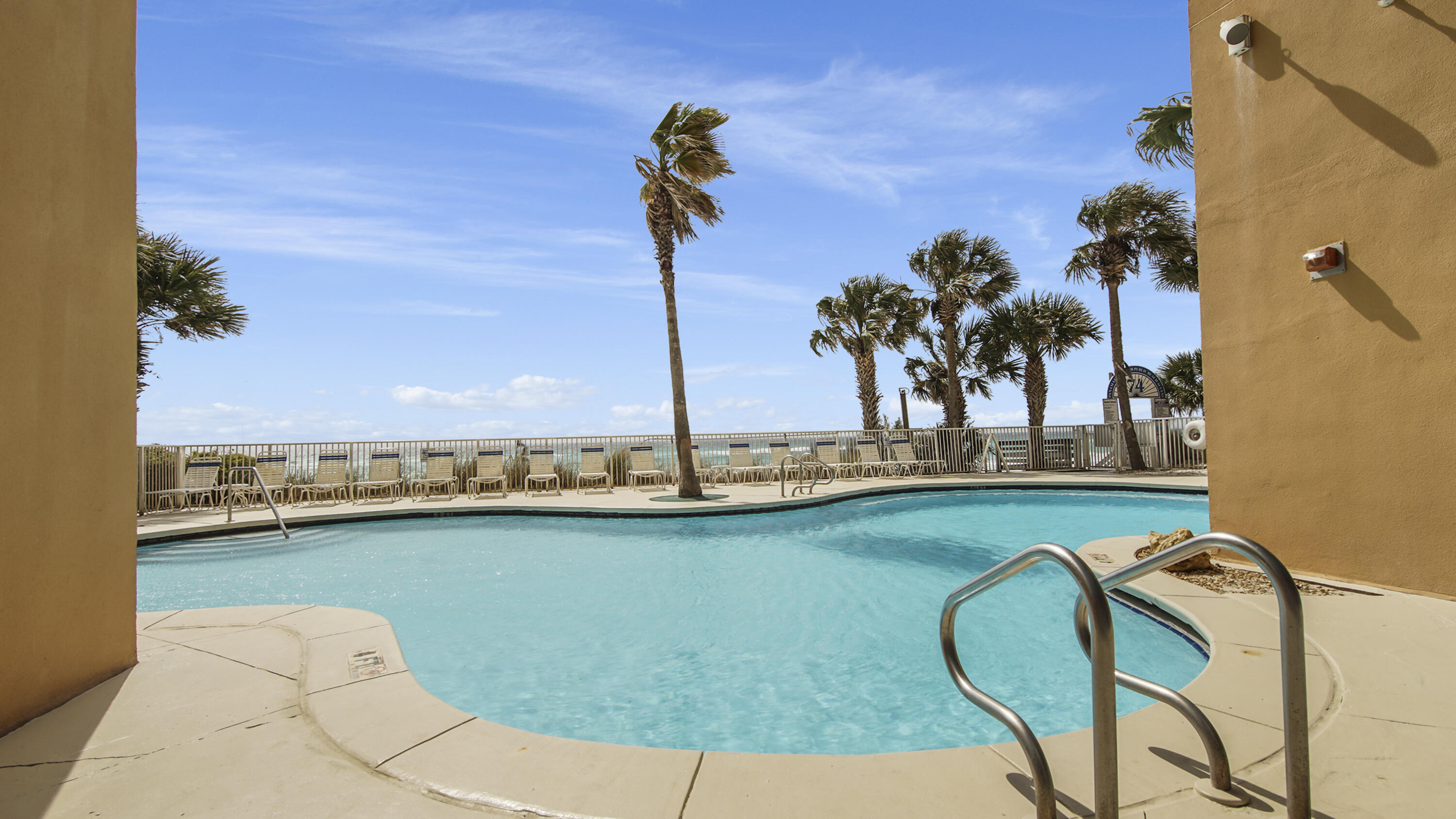 17739 Front Beach Road, Unit 507W Panama City Beach, FL 32413 - Photo 44 of 49 a view of a swimming pool with a table and chairs