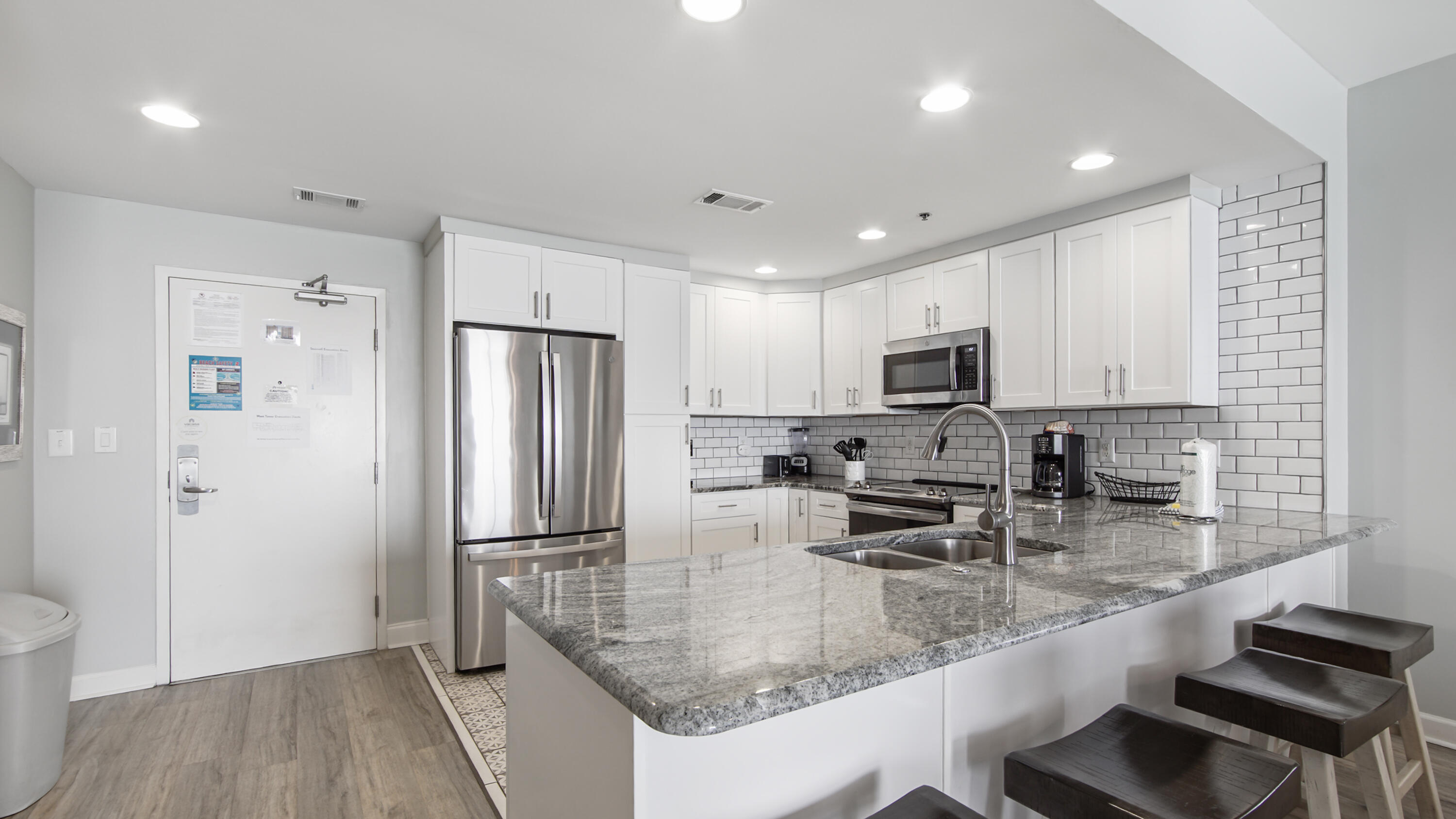 17739 Front Beach Road, Unit 507W Panama City Beach, FL 32413 - Photo 10 of 49 a kitchen with stainless steel appliances granite countertop a sink refrigerator and microwave