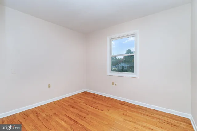 a view of a small space with wooden floor and a window