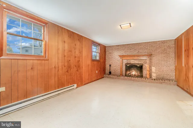 a view of an empty room with a window and fireplace