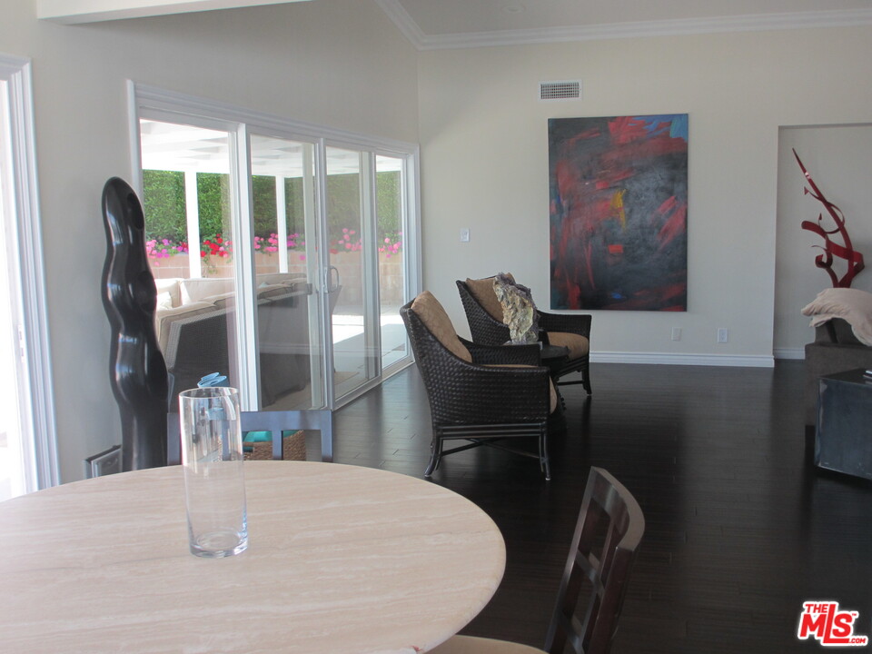 3641 Surfwood Road Malibu, CA 90265 - Photo 11 of 29 a view of a dining room with furniture wooden floor and a chandelier