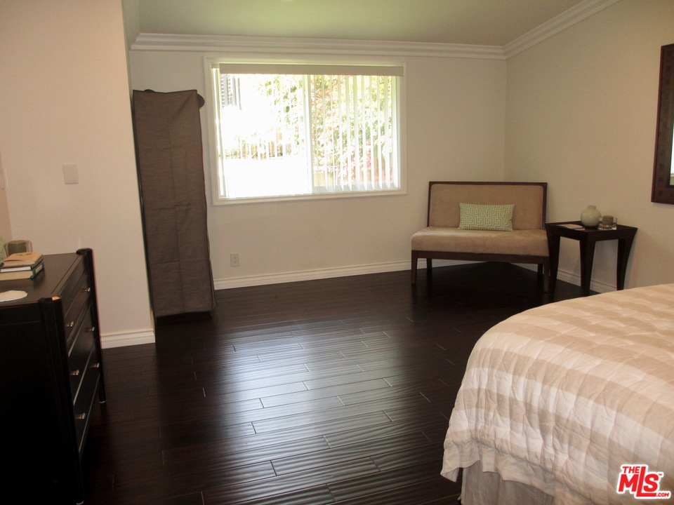 3641 Surfwood Road Malibu, CA 90265 - Photo 19 of 29 a bedroom with a bed and wooden floor