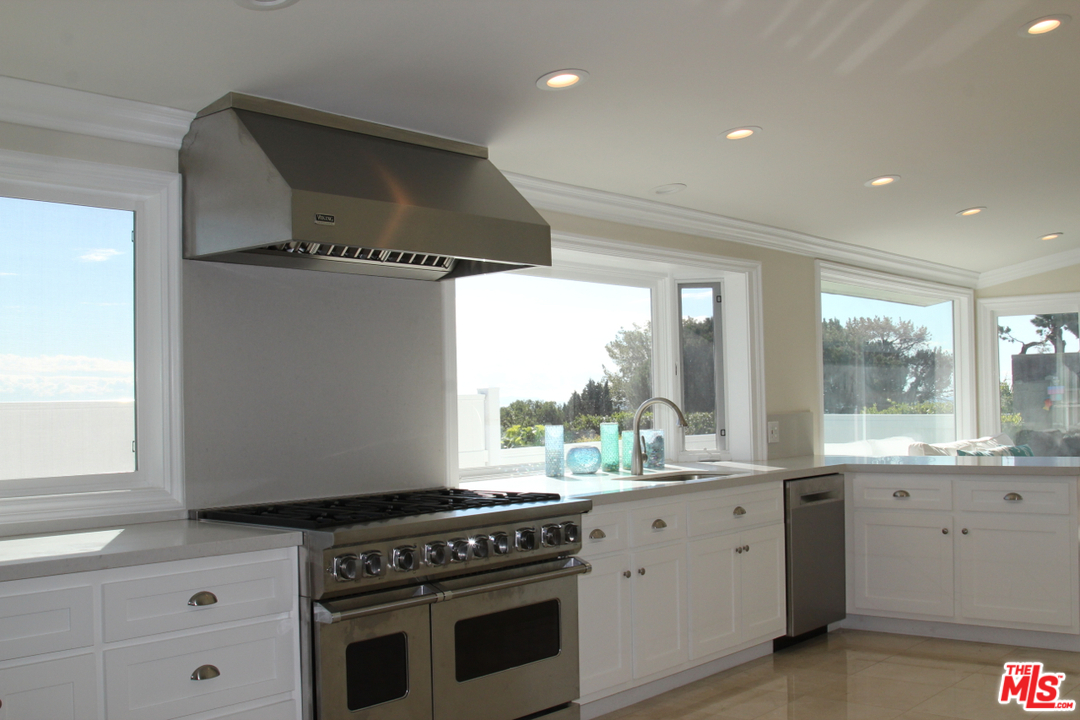 3641 Surfwood Road Malibu, CA 90265 - Photo 5 of 29 a kitchen with stainless steel appliances a stove a sink and a large window