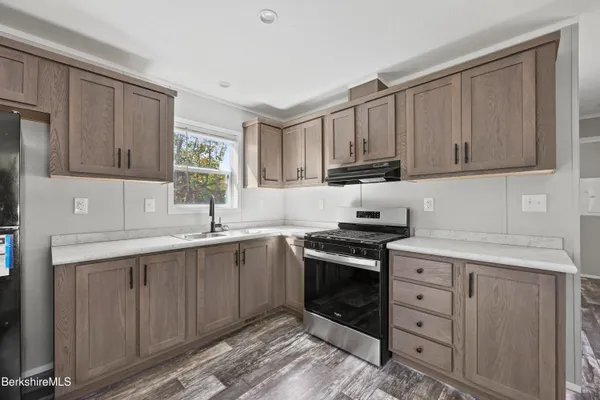 a kitchen with cabinets appliances a sink and a window