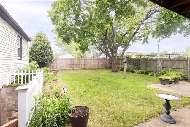 a view of a backyard with table and chairs under an umbrella