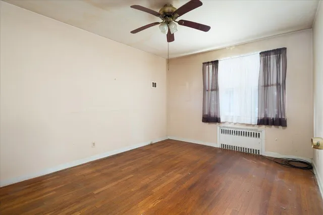 an empty room with a ceiling fan and windows