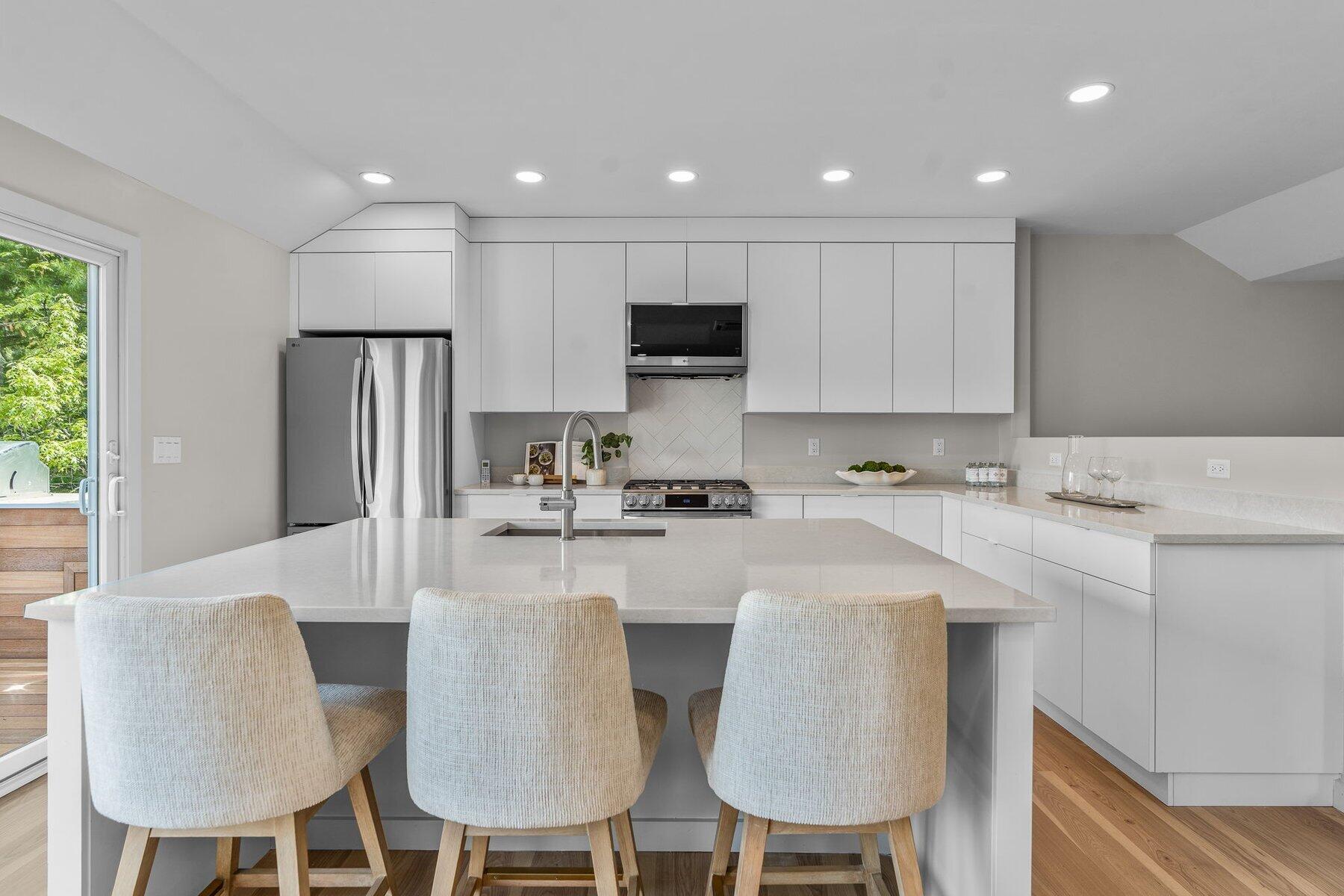 162 Main Street Osterville, MA 02655 - Photo 20 of 50 a kitchen with stainless steel appliances kitchen island granite countertop a dining table chairs refrigerator and sink