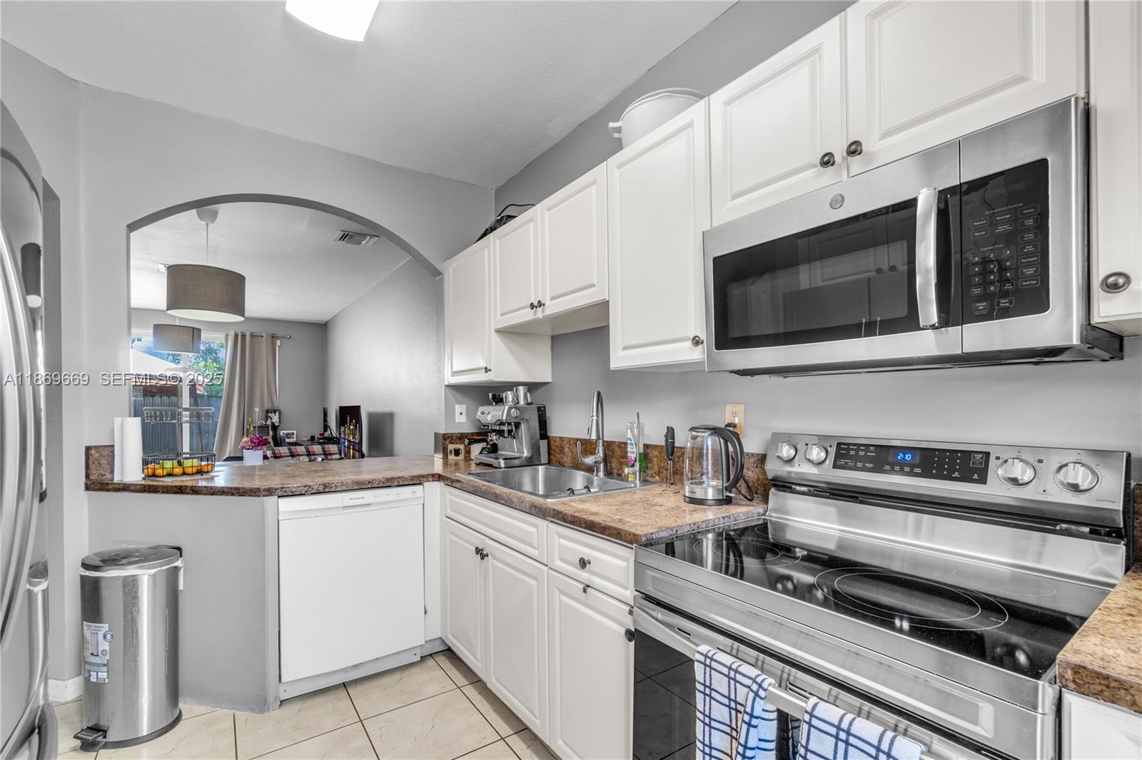 120 Southeast 6th Road Homestead, FL 33030 - Photo 9 of 31 a kitchen with stainless steel appliances granite countertop a stove a sink and a microwave