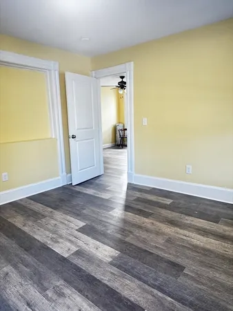 a view of a room with wooden floor and a window