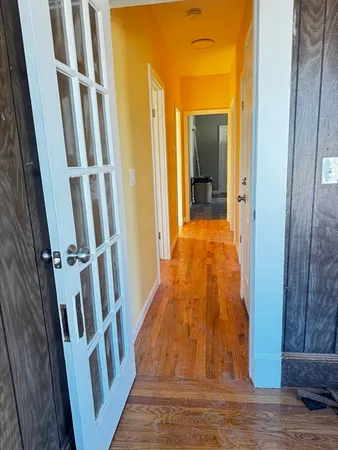 a view of a hallway with wooden floor and staircase