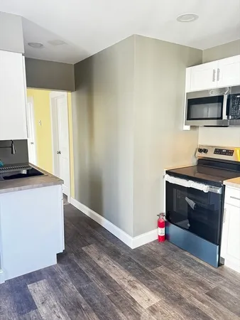 a living room with stainless steel appliances furniture a fireplace and a flat screen tv