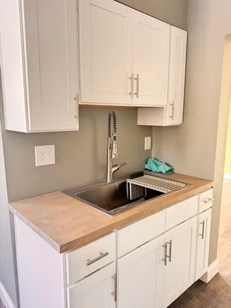 a kitchen with stainless steel appliances granite countertop white cabinets and a sink
