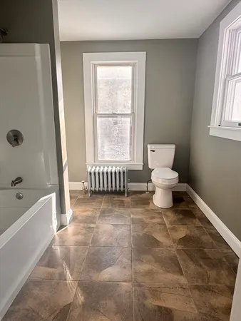 a spacious bathroom with a bathtub and toilet