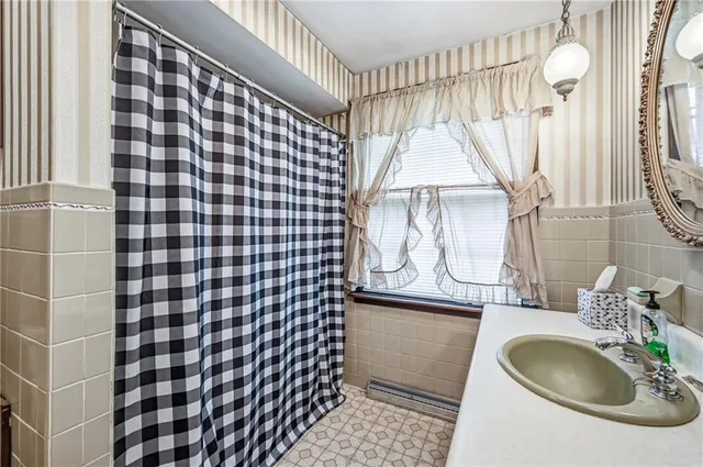 a bathroom with a sink a mirror and a shower