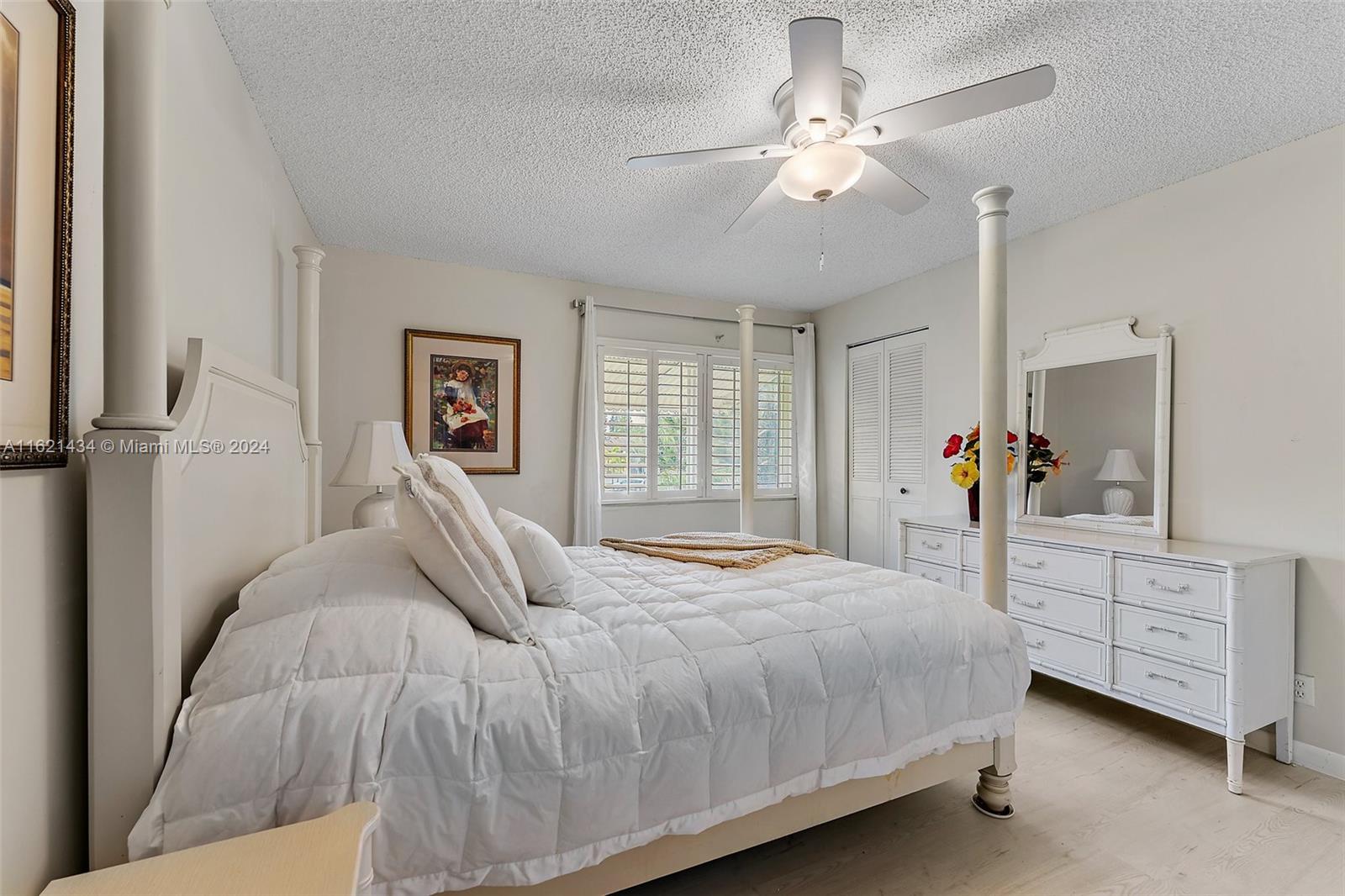 341 Pine Ridge Circle, Unit B2 Greenacres, FL 33463 - Photo 22 of 49 a bedroom with a large bed and a chandelier