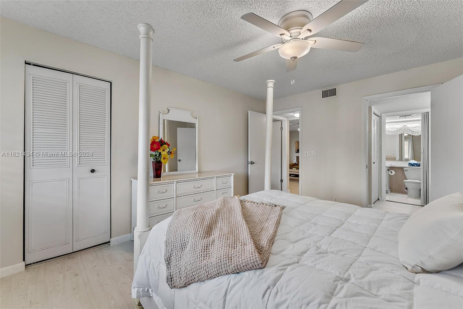341 Pine Ridge Circle, Unit B2 Greenacres, FL 33463 - Photo 23 of 49 a bedroom with a large bed and a chandelier