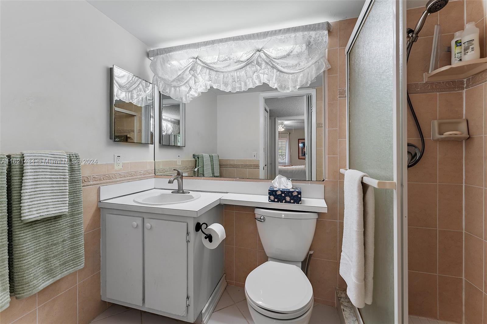341 Pine Ridge Circle, Unit B2 Greenacres, FL 33463 - Photo 27 of 49 a bathroom with a toilet a sink and mirror