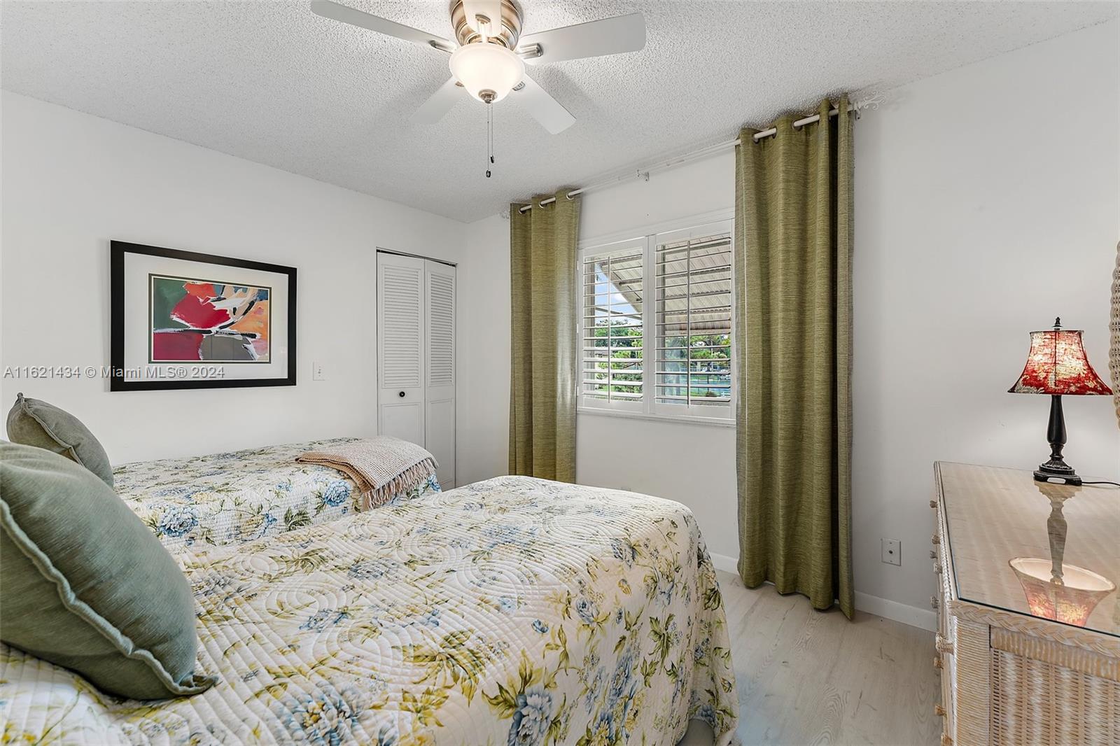 341 Pine Ridge Circle, Unit B2 Greenacres, FL 33463 - Photo 30 of 49 a bedroom with a bed and a chandelier