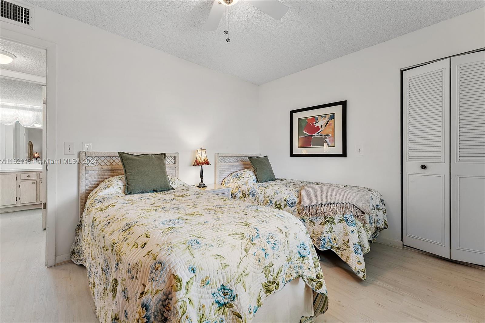 341 Pine Ridge Circle, Unit B2 Greenacres, FL 33463 - Photo 31 of 49 a bedroom with two beds and a painting on the wall