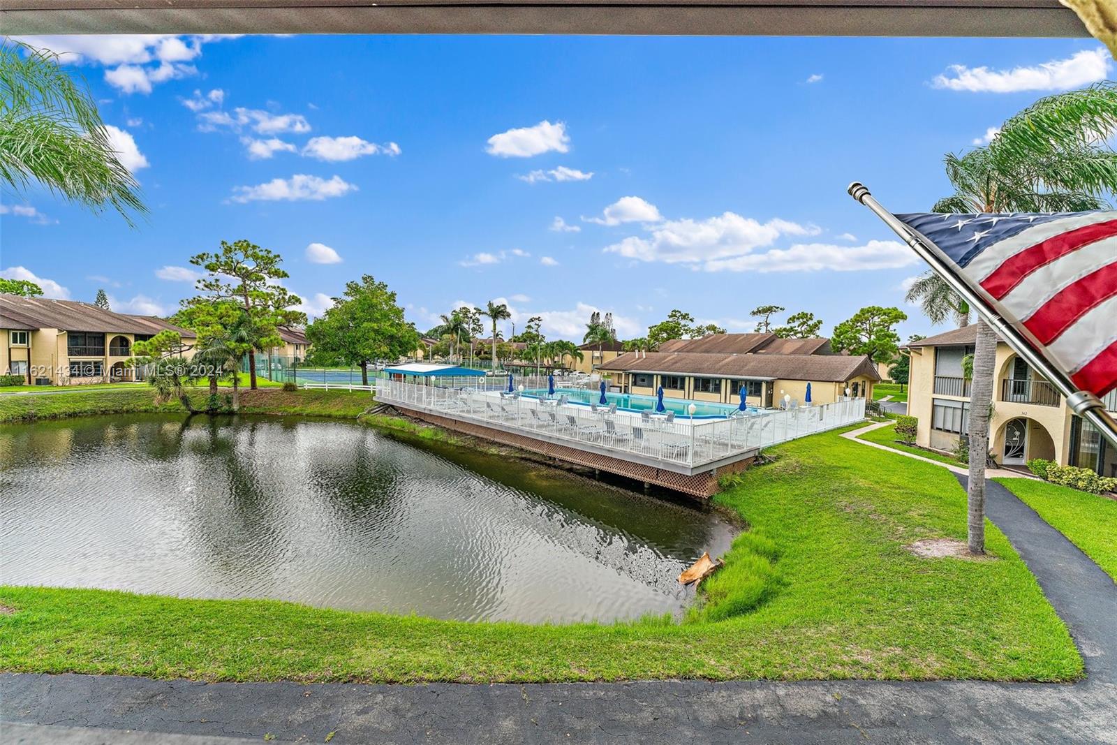 341 Pine Ridge Circle, Unit B2 Greenacres, FL 33463 - Photo 6 of 49 a view of a lake with a house in the background
