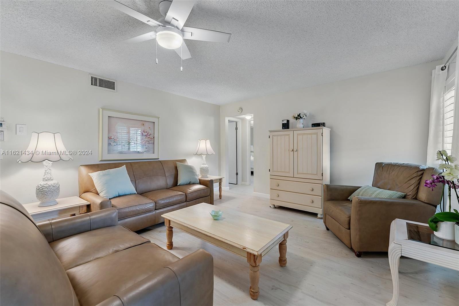 341 Pine Ridge Circle, Unit B2 Greenacres, FL 33463 - Photo 10 of 49 a living room with furniture and a wooden floor