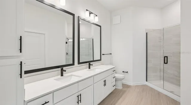 a bathroom with a double vanity sink mirror and toilet