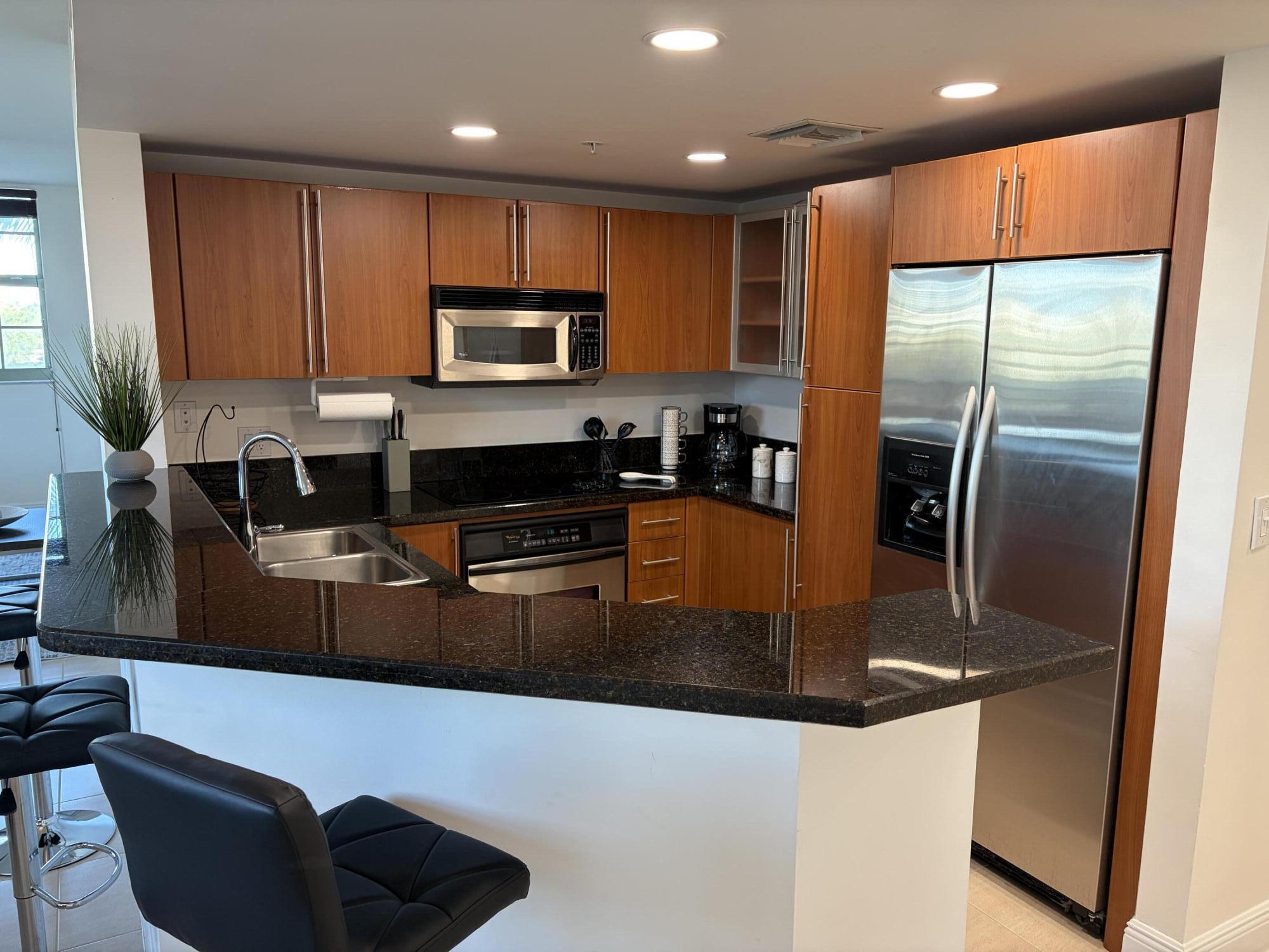 610 Clematis Street West Palm Beach, FL 33401 - Photo 3 of 33 a kitchen with stainless steel appliances granite countertop a refrigerator a stove a sink and a microwave