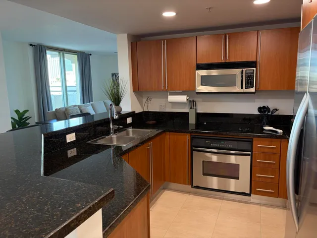 a kitchen with granite countertop a stove a sink and a microwave
