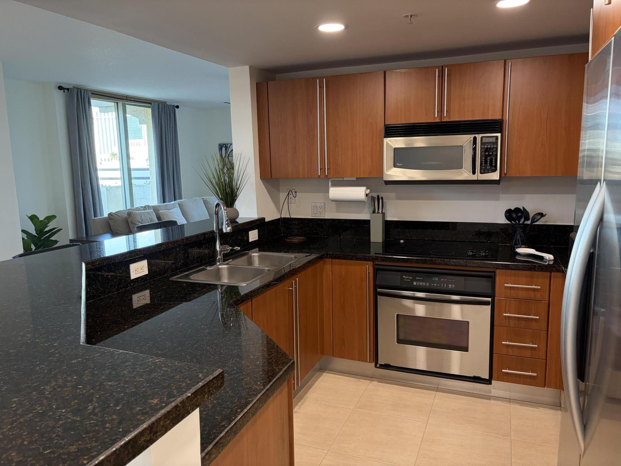 610 Clematis Street West Palm Beach, FL 33401 - Photo 4 of 33 a kitchen with granite countertop a stove a sink and a microwave