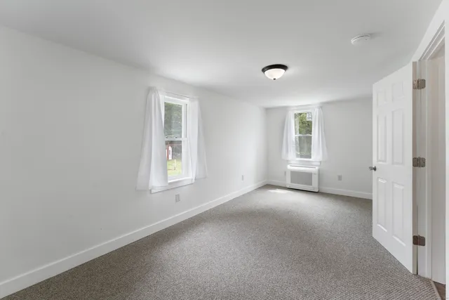 an empty room with windows and closet