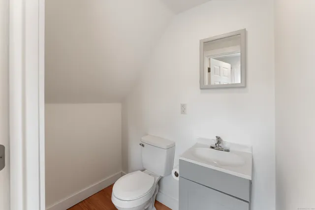a bathroom with a toilet a sink and mirror