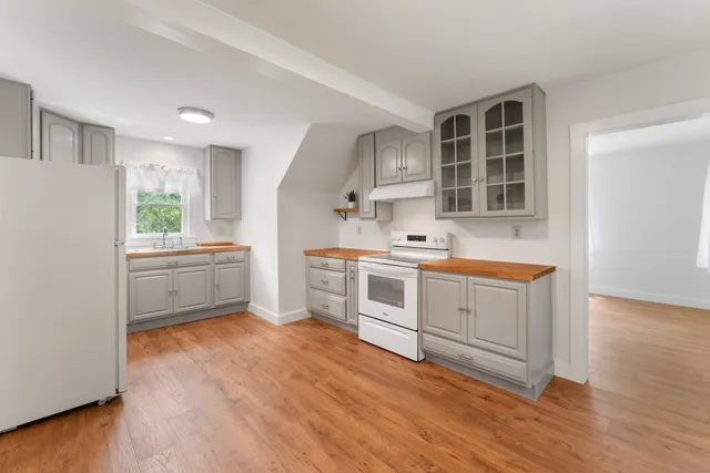 a kitchen with white cabinets and white appliances