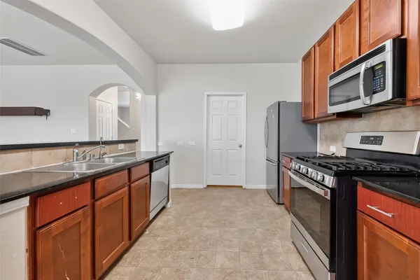 a kitchen with stainless steel appliances granite countertop a stove top oven a sink and dishwasher